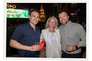 A photo of three people, a woman and two men, smiling for the camera at a Channel Partners networking event at TAO beach club in Las Vegas.