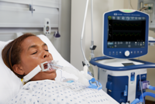 woman laying in hospital bed on ventilator