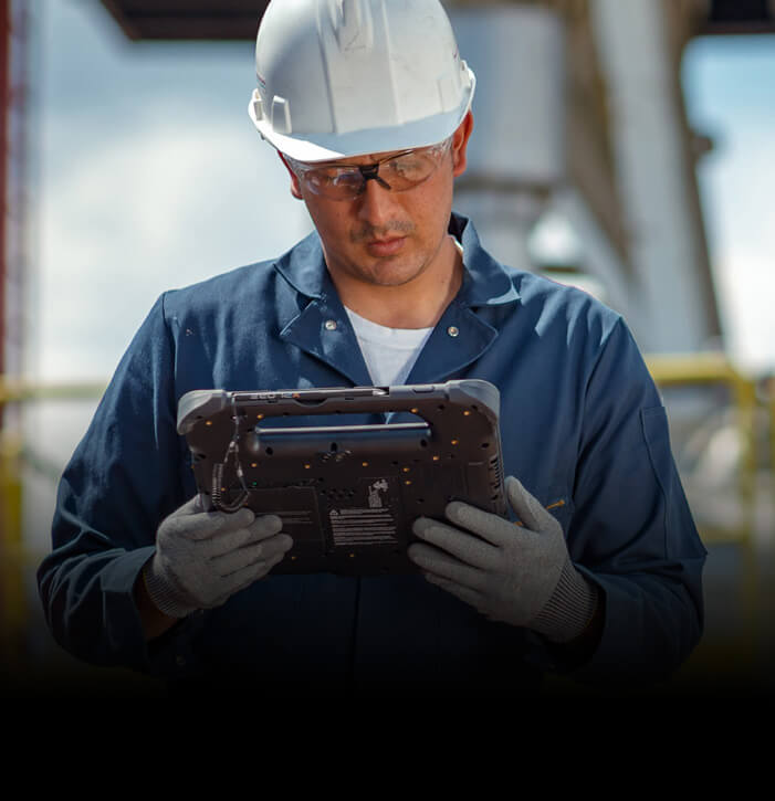 Outdoor field worker wearing hard hat and PPE looking at screen of Zebra tablet