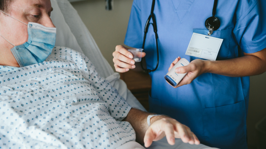 A nurse using a Zebra scanner to scan a patient's id band before giving him his medicine