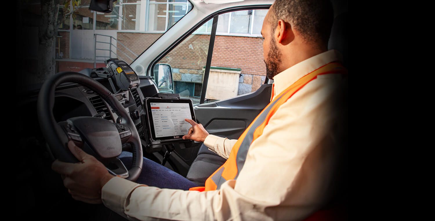 Service technician inside vehicle operating Zebra tablet next to him