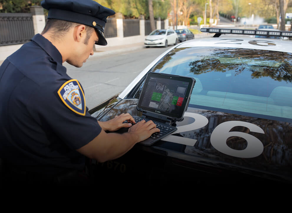 Police officer using Zebra's Rugged Tablet on the back of his squad car